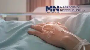 A hand with an IV in a hospital bed