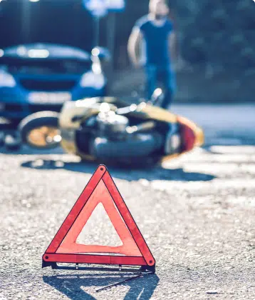 a waring sign in front of a motorcycle accident
