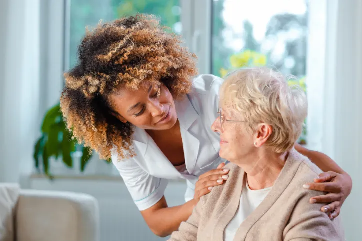 Nursing home staff interacting with an elderly woman.